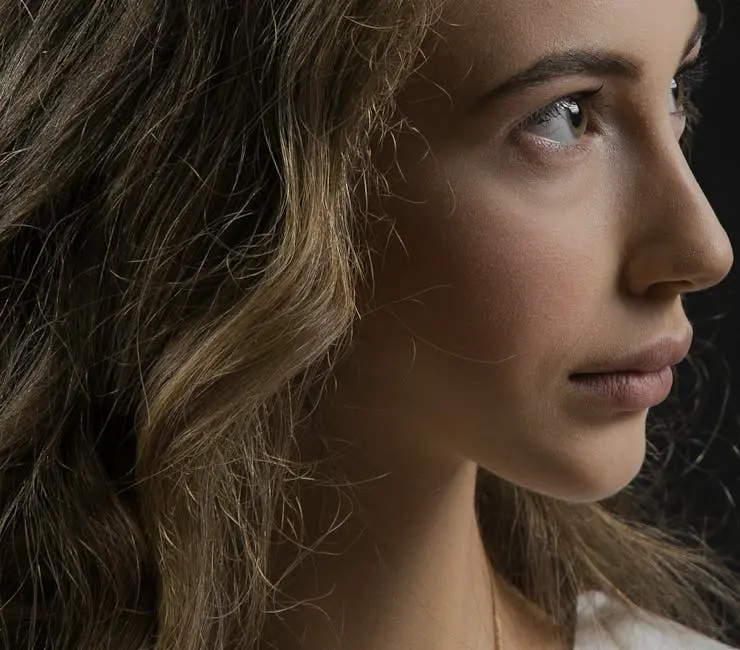 Close-up profile portrait of a woman with blond hair, showcasing detailed facial features.